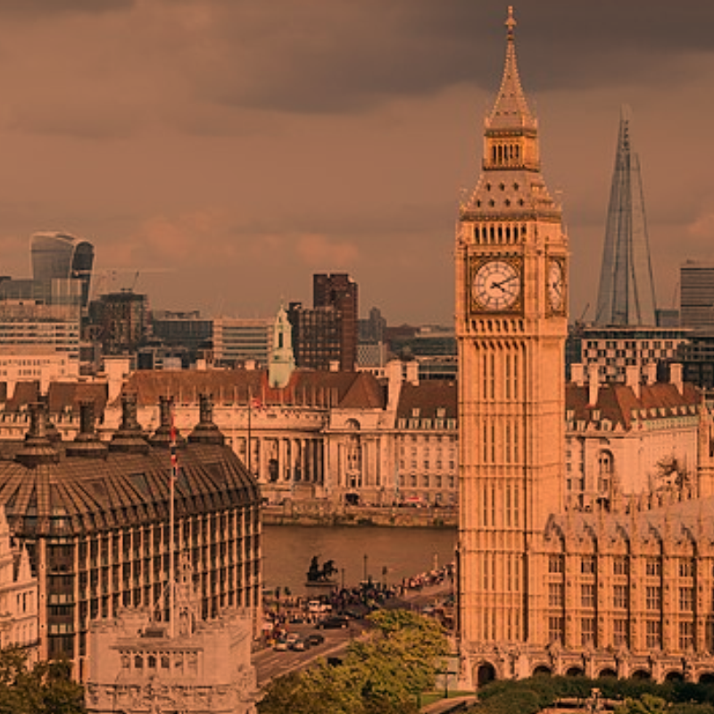 A London cityscape is painted in orange with the light of a sunset.