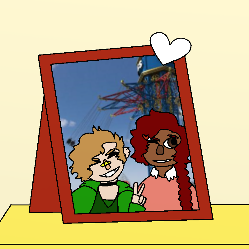 A framed photo of Amada with somebody. Amada's hair is in a braid. The other person is pale, with short, choppy brown hair. Bud has a band-aid across bud's nose. Both are smiling.